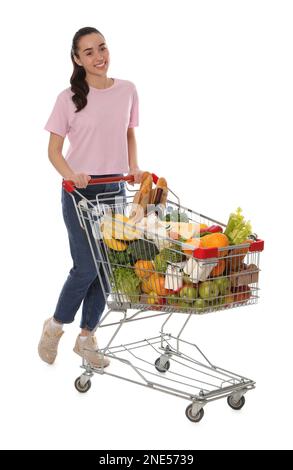 Donna felice con carrello di shopping pieno di generi alimentari su sfondo bianco Foto Stock