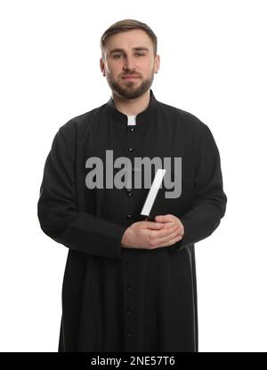 Sacerdote in cassock con la Bibbia su sfondo bianco Foto Stock