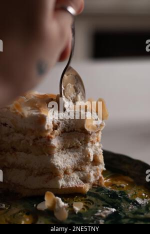 Vista sul processo di mangiare cremoso torta di mandorle il compleanno Foto Stock