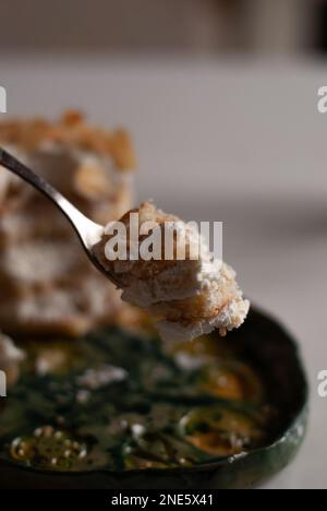 Un pezzo di torta cremosa alle mandorle su un cucchiaio Foto Stock