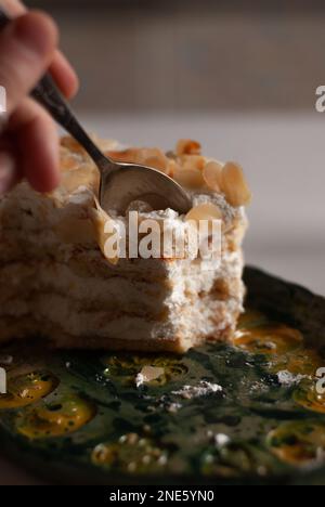 Vista sul processo di mangiare cremoso torta di mandorle Foto Stock