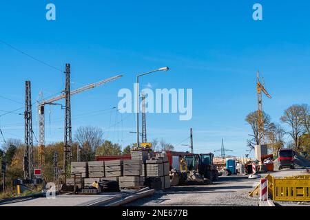 Cantiere con macchine e gru da cantiere. Impilamento di materiali stradali. Foto Stock