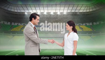 Composizione di uomo d'affari e donna d'affari che scuotono le mani sullo stadio sportivo Foto Stock