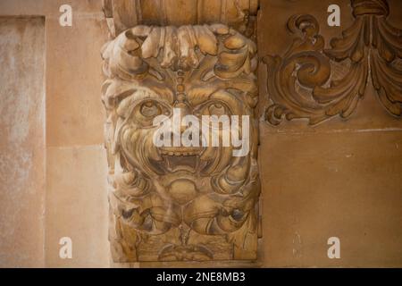 Particolare di una maschera facciale umana nel balcone decorato di palazzo Nicolaci in via Nicolaci, noto, Sicilia, Italia, Foto Stock