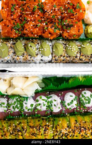 Set misto di vari sushi Maki assortiti con salmone, tonno, caviale, avocado, condito con salsa, Zenzero, formaggio, semi di sesamo. Giapponese orientale c Foto Stock