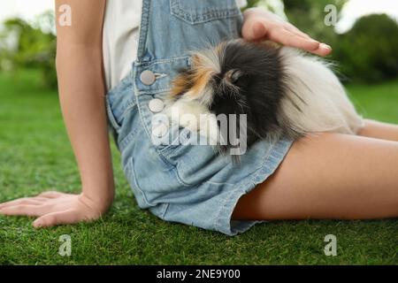 Bambina con cavia all'aperto, primo piano. Animale domestico di infanzia Foto Stock