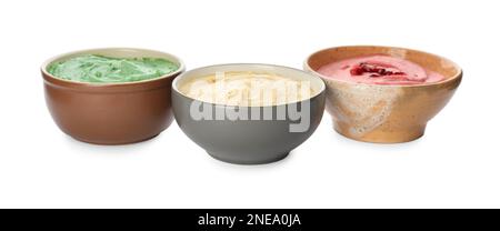 Diversi tipi di hummus gustoso in ciotole su sfondo bianco Foto Stock