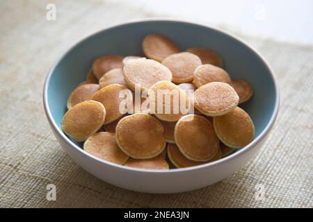 Mini frittelle di cereali con burro e frutta rossa in un recipiente. Foto Stock