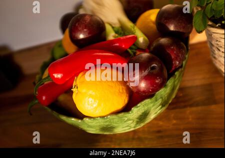 Ciotola di frutta contenente finocchio , prugne , peperoncini rossi e limoni Foto Stock