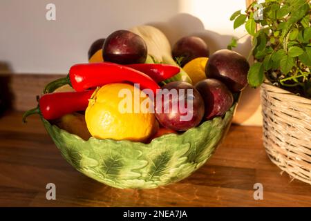 Ciotola di frutta contenente finocchio , prugne , peperoncini rossi e limoni Foto Stock