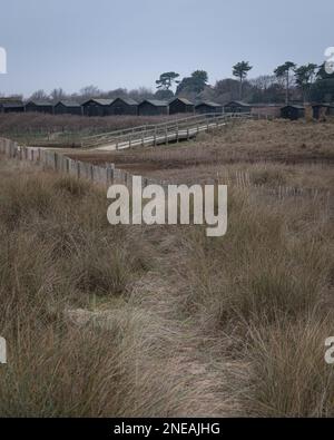 Capanne nere a Walberswick, Suffolk. Grigio, giorno di Moody. Inverno, febbraio. Foto Stock