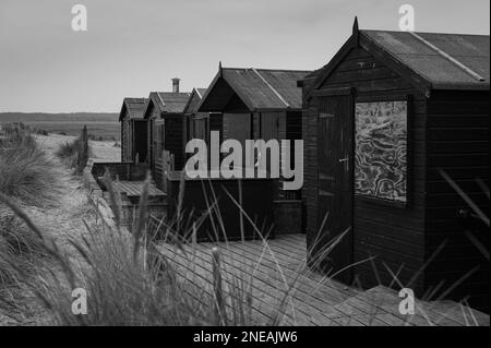 Capanne nere a Walberswick, Suffolk. Grigio, giorno di Moody. Foto Stock