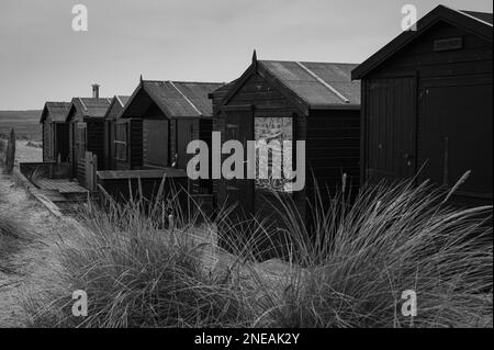 Capanne nere a Walberswick, Suffolk. Grigio, giorno di Moody. Foto Stock