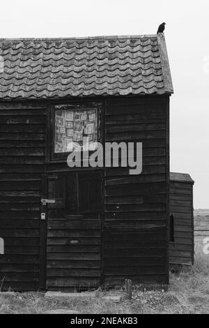 Capanne nere a Walberswick, Suffolk. Grigio, giorno di Moody. Foto Stock