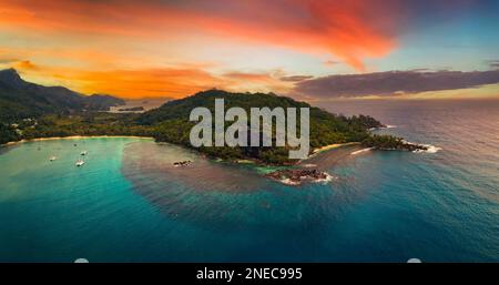 Vista aerea del tramonto sulla spiaggia di Port Launay sull'isola di Mahe, Seychelles Foto Stock