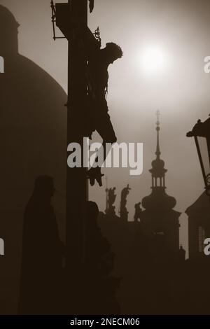 Praga - croce da H. Hilger 1629 sul Ponte Carlo da sunrise - silhouette Foto Stock