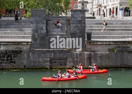 Città di Lubiana, Slovenia, gente in kayak sul fiume Lubiana presso l'argine di New Square (Novi Trg), tour in kayak o in canoa è un tour popolare Foto Stock
