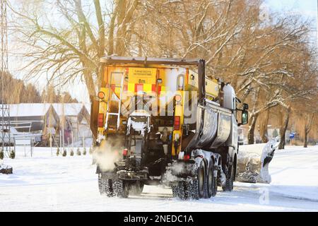 Autocarro dotato di spazzaneve e spargitore di sale stradale in movimento dopo le nevicate invernali nel sud della Finlandia. Salo, Finlandia. Febbraio 11, 2023. Foto Stock