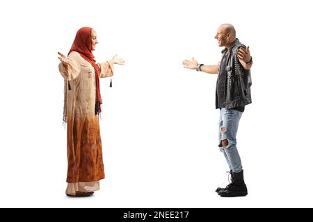 Profilo a tutta lunghezza di una donna che indossa un hijab e incontra un uomo punk calvo isolato su sfondo bianco Foto Stock