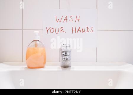 lavarsi le mani - cartello di avviso scritto a mano sopra il bagno o il lavandino del bagno - l'igiene previene le infezioni Foto Stock