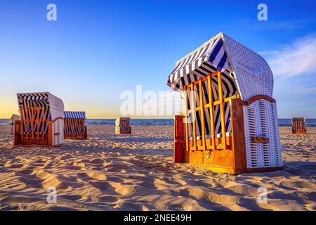 sedie da spiaggia chiuse contro il tramonto Foto Stock