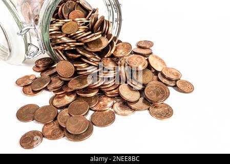 piccole monete euro cent cambio che si riversano dal vaso di vetro isolato su sfondo bianco, ritiro del concetto di monete a bassa denominazione Foto Stock