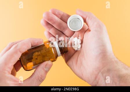 primo piano delle mani che dispensano le compresse dal flacone di pillola, concetto di farmaco Foto Stock