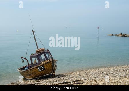 Una tradizionale vecchia barca da pesca a scafo di legno sulla spiaggia di ciottoli a Sidmouth, Devon, Inghilterra Foto Stock