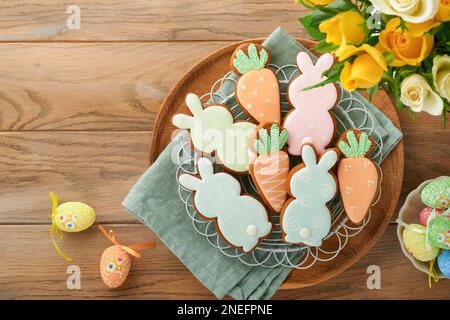 Colazione di Pasqua, concetto di Holliday. Pan di zenzero pasquale forma di coniglietto e carota con cannella con smalto colorato, decorazioni pasquali, uova colorate su Foto Stock