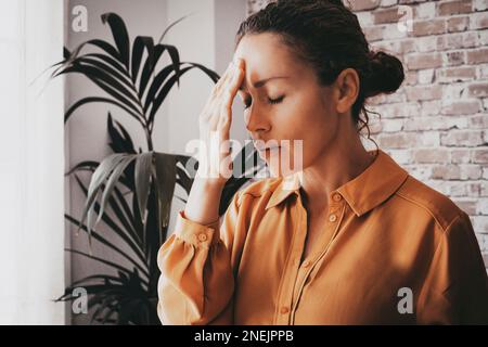 Stanco donna d'affari stressata sensibilità forte emicrania che massaggiano le tempie esaurite da lavoro eccessivo, lavoratore esecutivo della signora sopraffatta affaticato che soffre f Foto Stock