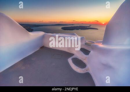 Il sole tramonta sulla caldera vista da una terrazza che si affaccia sul mare, Santorini Foto Stock