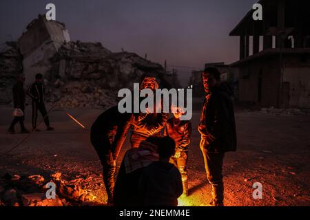 Jindires, Siria. 16th Feb, 2023. I siriani si scaldano accanto alle macerie della casa, distrutta dal terremoto che ha colpito il confine turco-siriano. Credit: ANAS Alkharboutli/dpa/Alamy Live News Foto Stock