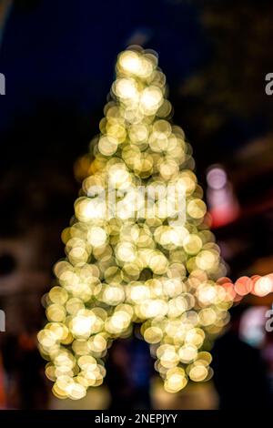 Luci bokeh sfocate a Napoli. Florida Downtown sera notte Natale albero festa decorazioni stagione su 13th Avenue Foto Stock