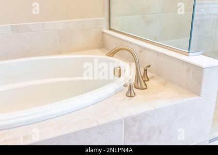 Moderno bagno bianco pulito e closeup di vasca da bagno con doccia e piastrelle in modello palco casa, casa o appartamento Foto Stock