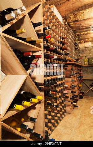 Cantina di vini a temperatura controllata nel seminterrato all'interno di una vecchia casa in pietra tagliata in stile cottage del 1820 e in pietra di campo. Foto Stock