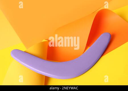 Composizione creativa con boomerang lilla in legno su sfondo colorato Foto Stock
