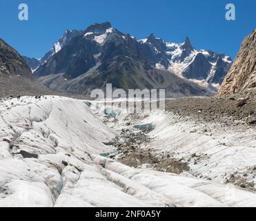 Il torrente glaciale sul ghiacciaio Mer de Glace con il Garand Jorasses sullo sfondo. Foto Stock