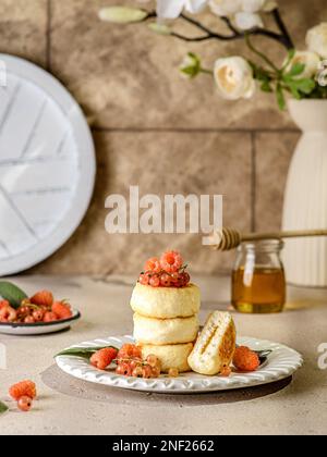 cheesecake casolare con lamponi e ribes. accanto a un vaso di fiori Foto Stock