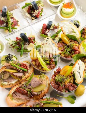 spuntini assortiti per il catering alla luce. tartare, bruschetta, insalate, patate, tartine da consegnare in scatola di cartone Foto Stock