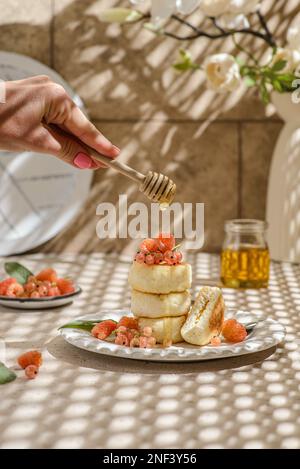 cheesecake casolare con lamponi e ribes. accanto a un vaso di fiori Foto Stock