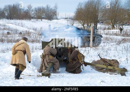 KRASNOYE SELO, RUSSIA - 05 FEBBRAIO 2023: Gli artiglieri sovietici sparano contro una pistola d'assalto tedesca semovente. Ricostruzione militare-storica della battaglia Foto Stock