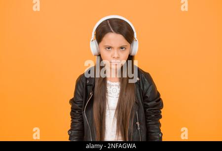 Percezione dei suoni. Testi di apprendimento. Le tendenze della musica plasmano il futuro. Gusto musicale. Accessorio musicale. Negozio di gadget. Piccola ragazza che ascolta la musica senza fili Foto Stock