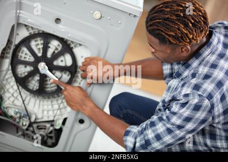Il tecnico di riparazione di una macchina di lavaggio Foto Stock