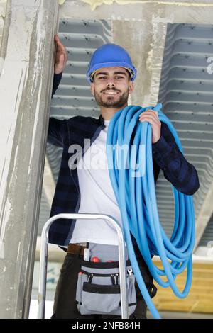 lavoratore in uniforme blu con tubi di ventilazione Foto Stock