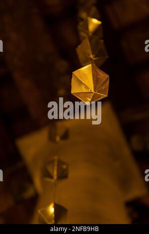 Basso dettaglio angolare di un diamante dorato appeso al soffitto in legno del portico dei granollers seguito da due o più sopra di esso. Vista rapporto verticale in m Foto Stock