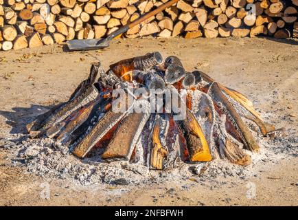 Cima di un grande falò circolare imballato con legna da ardere sui lati che il fumo proviene dai tronchi di legno in una festa popolare villaggio per la rura tipica Foto Stock