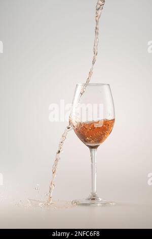 vino rosato mancante versando nel bicchiere Foto Stock