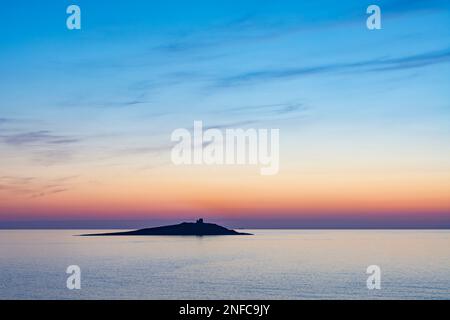 Il sole tramonta dietro l'isolotto di Isola delle femmine, in Sicilia Foto Stock
