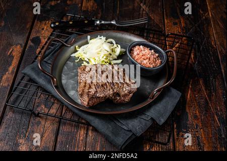 Bistecca di cervo con sale marino e insalata. Sfondo di legno. Vista dall'alto. Foto Stock