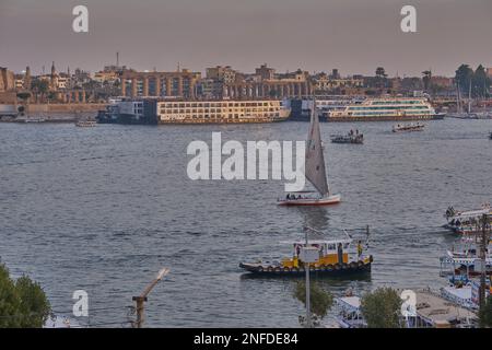 Luxor, Egitto tramonto girato dalla riva ovest mostrando il fiume Nilo con Felucche, navi da crociera e Luxor Tempio in riva est Foto Stock